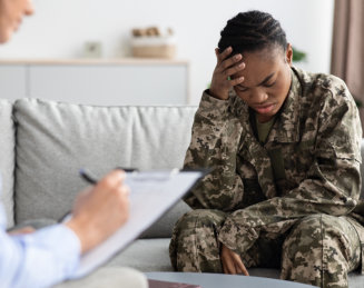 female in uniform talking sadly to his counselor