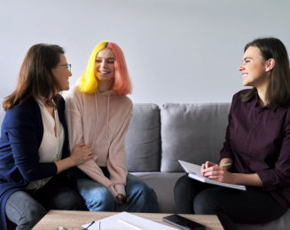 teenager with her mom talking to their psychiatrist