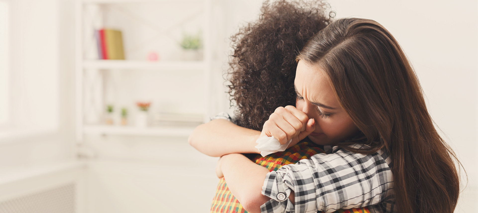 two woman hugging and crying