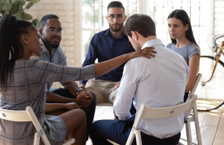 african american female employee putting hand on coworkers shoulder