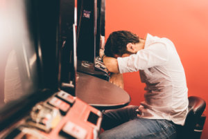 man having gambling addiction inside a casino