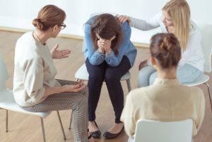 woman comforted during a session with her group